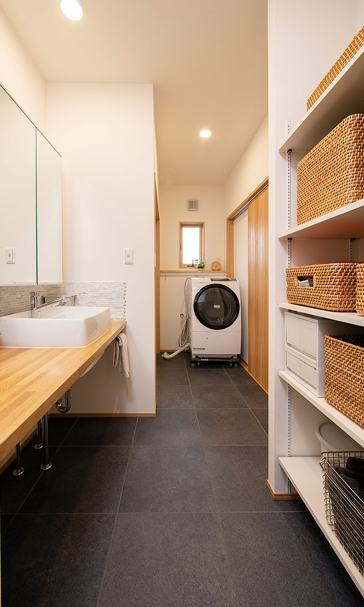 収納たっぷりの洗面室。スタイリッシュなカウンタータイプの洗面台は家事をするのにも便利。