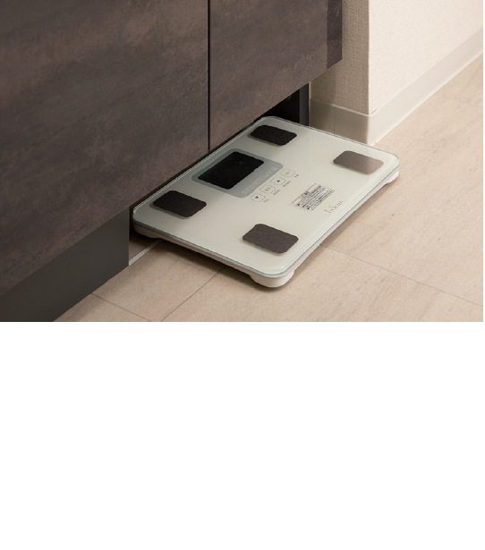 ヘルスメーター収納スペース,洗面化粧台の巾木部分を有効活用してヘルスメーターの収納スペースを設置。使用しない時はしっかりしまえ、使用する際はサッと出すことができます。